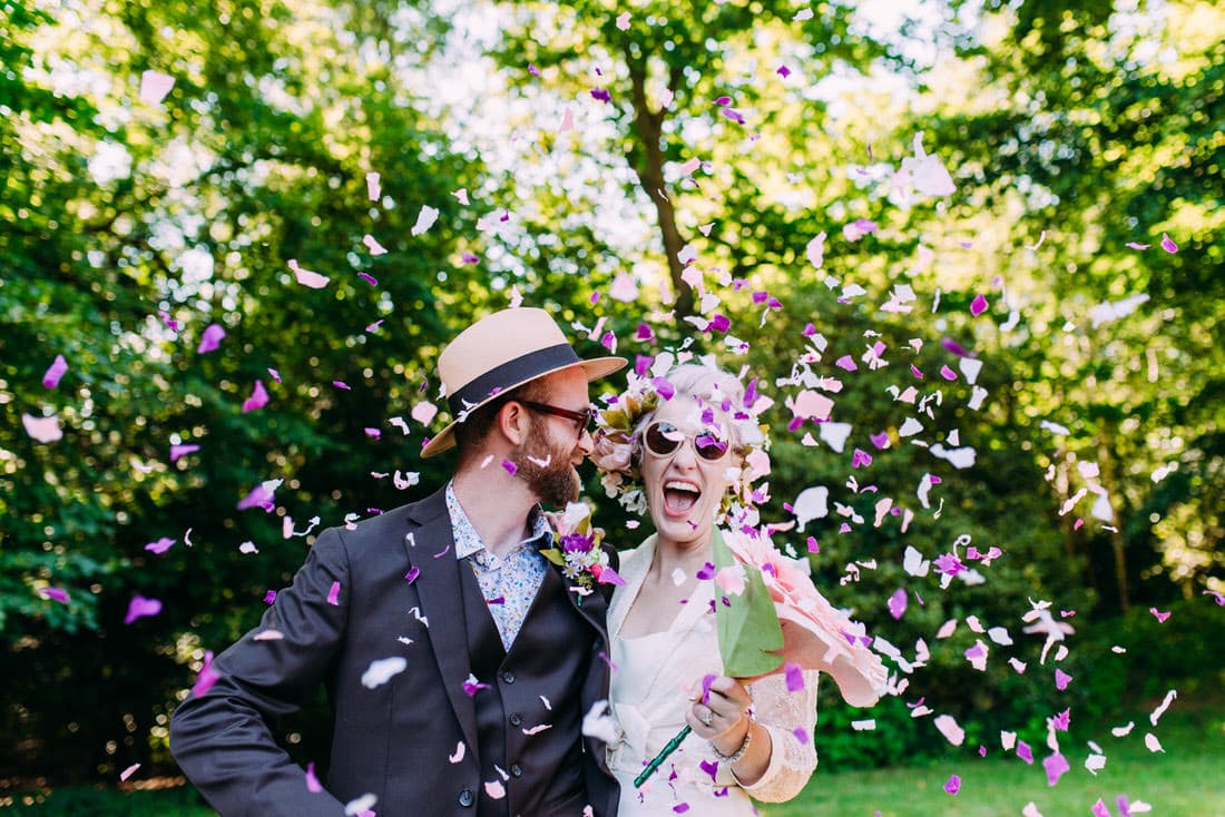 bride and groom covered in confetti during orchard wedding in kent