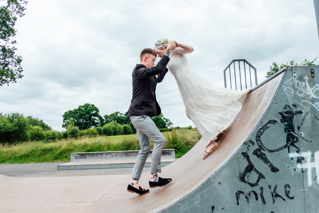 bride and groom on a skate ramp at a skate park