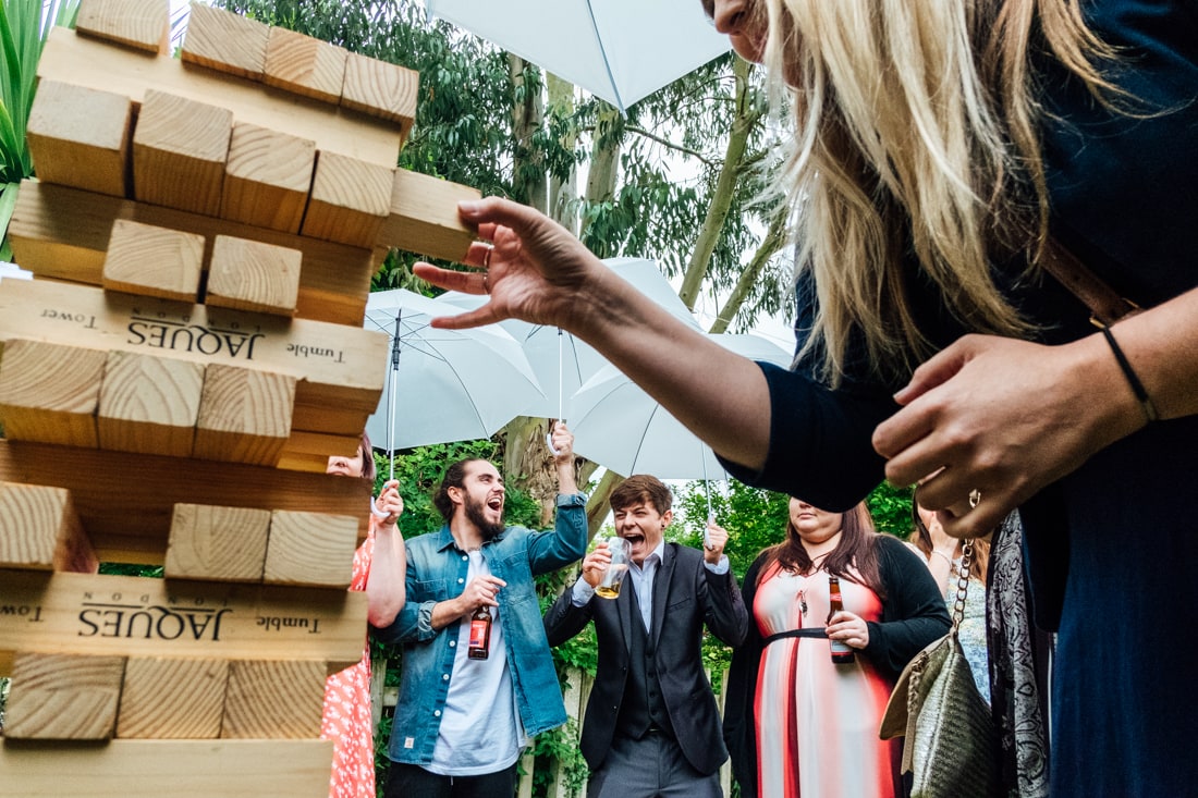 guests playing giant jenga at a back garden wedding in kent