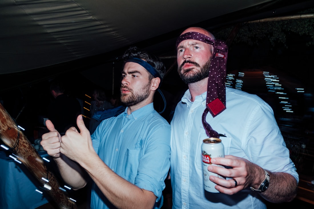 groom on dancefloor with tie around his head